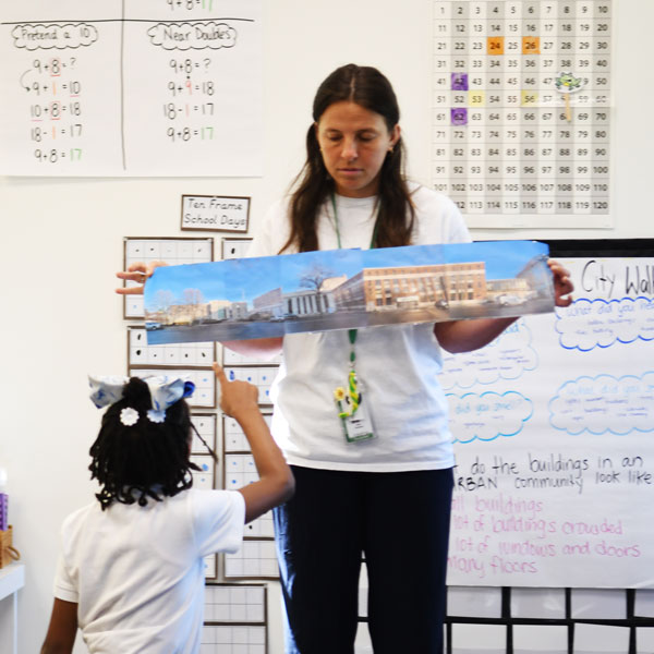 Teacher holding a poster or a city block