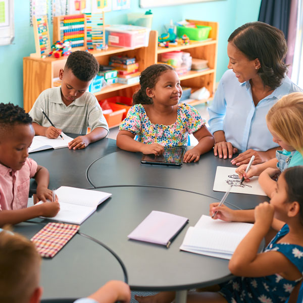 students in desks facing each other in grade school class