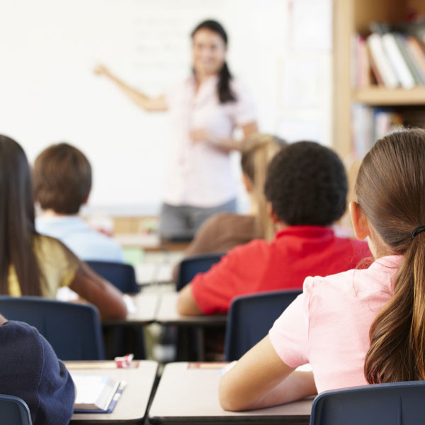 Teacher at white board in front of a classroom