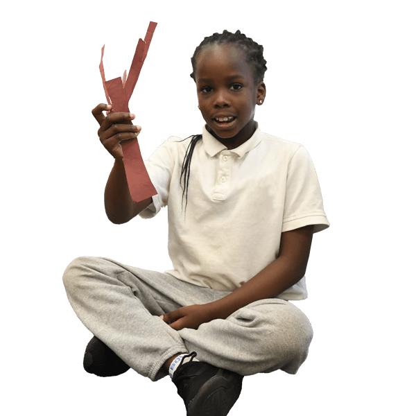 Elementary school student displaying a cinstruction paper craft