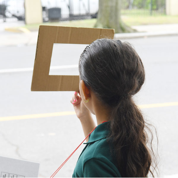 young female student discovering geometric chapes outdoors