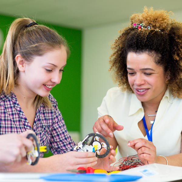 Teacher working with female high school student on robotics project