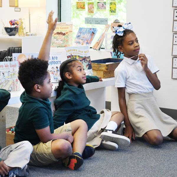 a student raising his hand to answer a question